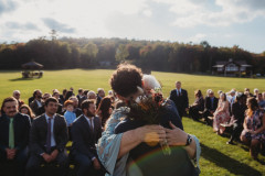 groom hugging mother on wedding knoll.