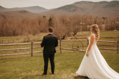 bride walking towards groom for a first look with mountain scape in background.