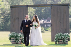 bride and father of bride walking through barn doors