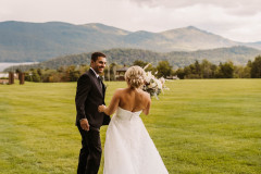 bride and groom in meadow during first look smiling at each other. 