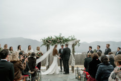 bride and groom on terrace exchanging vows in the winter. 