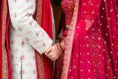 indian-based ceremony featuring bride and groom close up of hands.