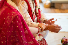 indian-based ceremony featuring bride and groom close up of hands.