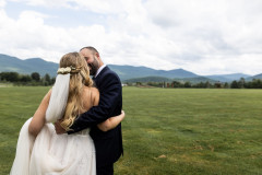bride and groom kissing with mountains in background.