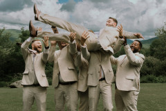 groom being lifted up by groomsment