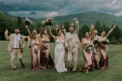 bride and groom walking towards camera with wedding party