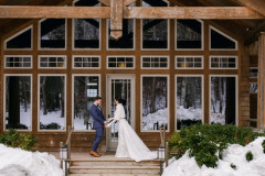 first look photo of bride and groom in front of guest house on top of stairs leading to front door.