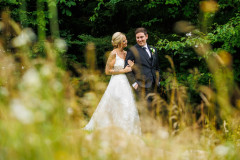 bride and groom standing in field