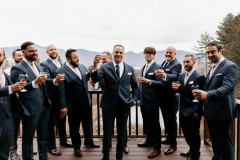 groom with groomsmen raising glasses