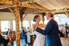 bride and father of bride dancing under event barn and lighting.
