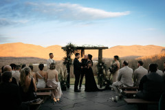 Wedding ceremony on patio with mountains in background.