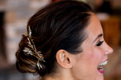 profile photo of brunette woman laughing, hair is in up-do with ornate hair clip.