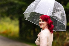 bride standing under umbrella.