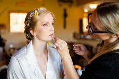 bride having makeup done by makeup artist for a wedding.