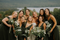 bride and bridesmaids in front of camera with bouquets