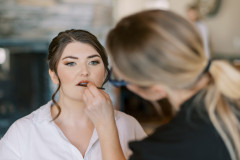 bride getting makeup done by makeup artist.