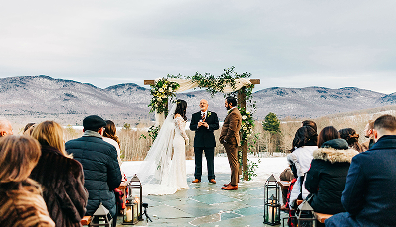 wedding ceremony in front of mountain with bride, groom and minister standing at altar with people watching at Mountain Top Inn & Resort in Chittenden, VT